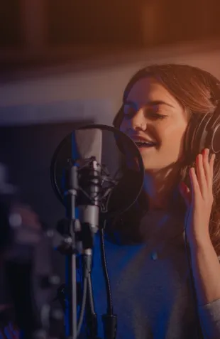 Cantante grabando en un estudio con audífonos